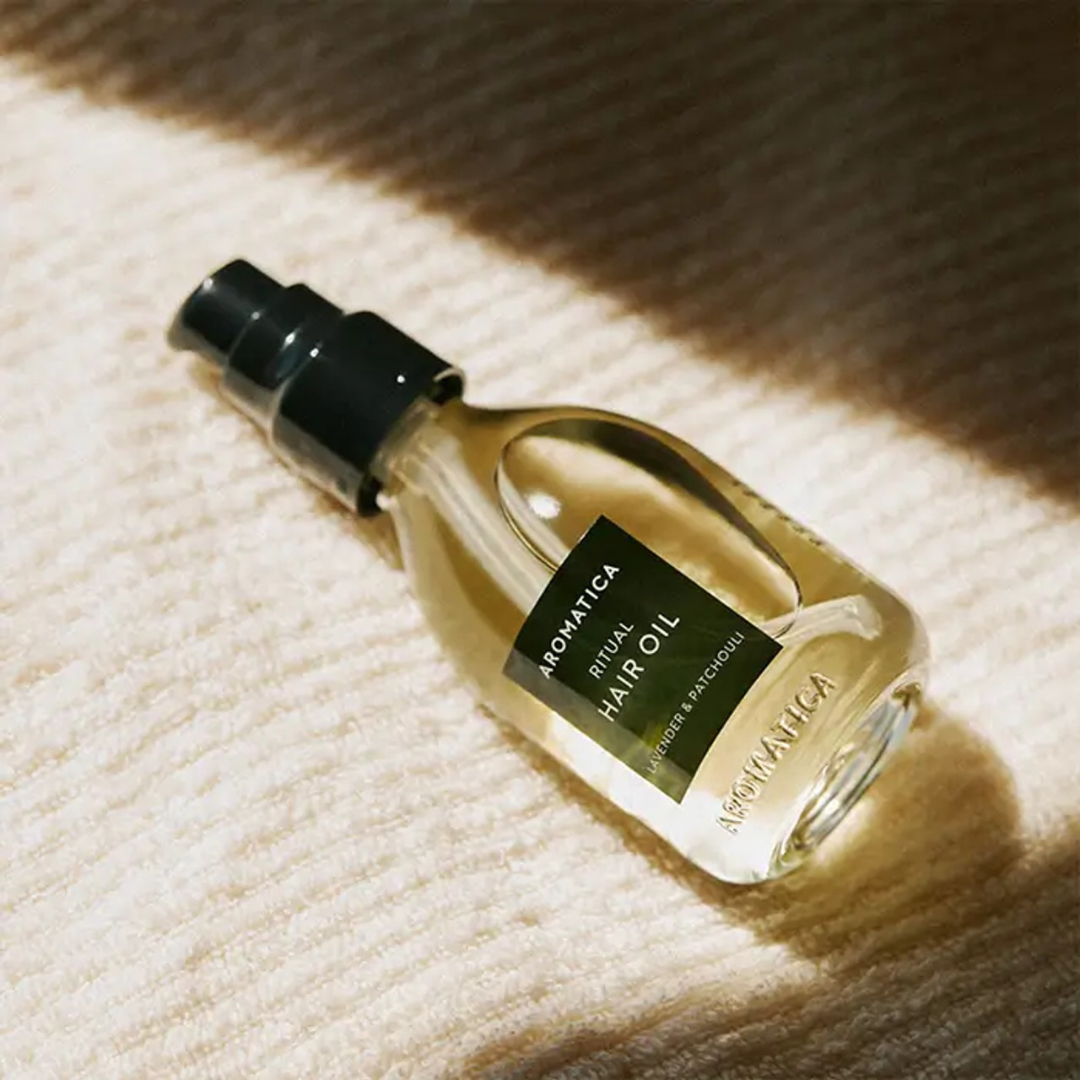 Aromatica Ritual Hair Oil with lavender and patchouli in a 50ml bottle, used for hair styling and nourishing.
