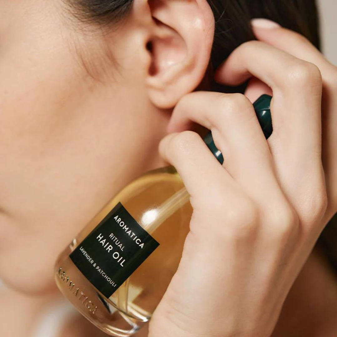 Aromatica Ritual Hair Oil Lavender & Patchouli 50ml bottle, featuring a clear glass container with a black cap, suitable for hair styling.