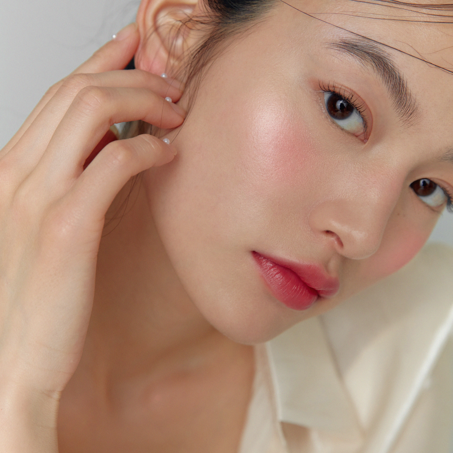 Hince True Dimension Glow Cheek blush in a soft pink shade, displayed in a sleek compact with a mirror.