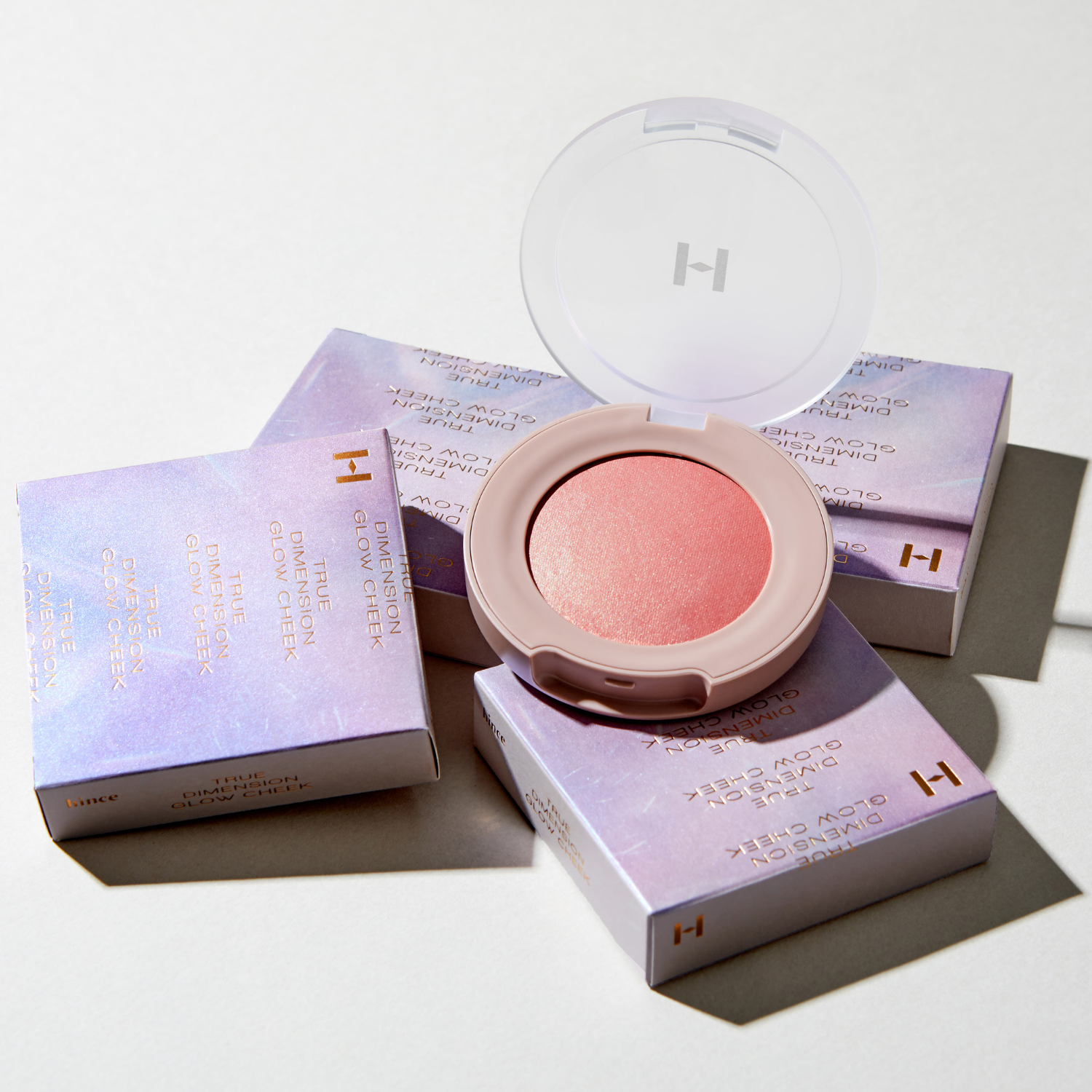 Hince True Dimension Glow Cheek blush compact with soft pink and peach shades, featuring a sleek, reflective surface and subtle branding.