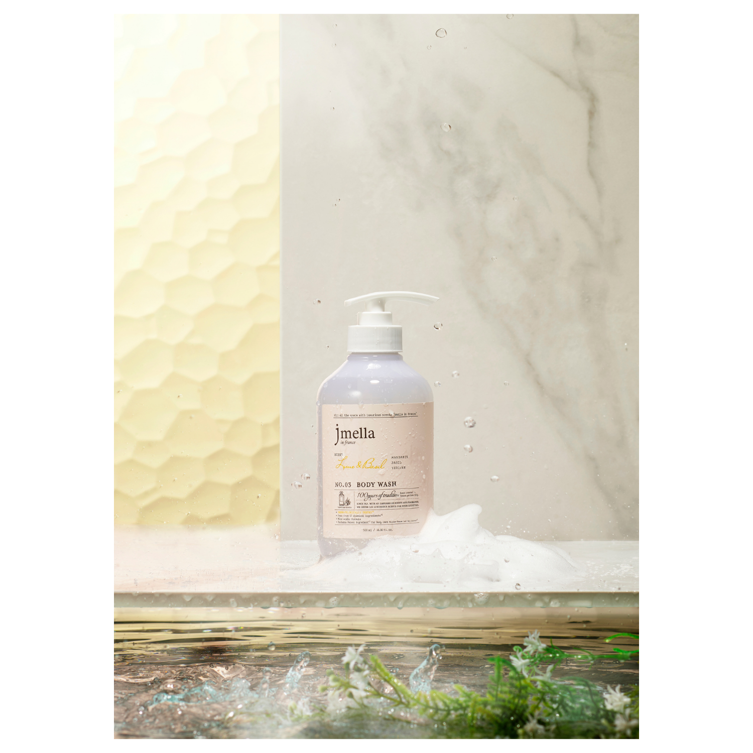 Jmella Lime & Basil Body Wash and Scrub bottle with lime slices and basil leaves, highlighting natural ingredients and refreshing scent.