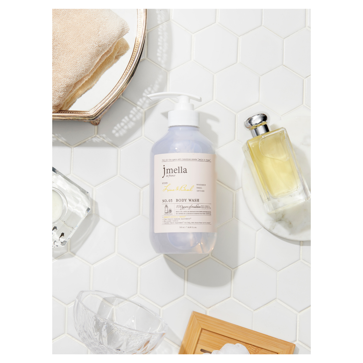 Jmella Lime & Basil Body Wash and Scrub in a clear bottle with green and white label, showing fresh citrus and basil ingredients