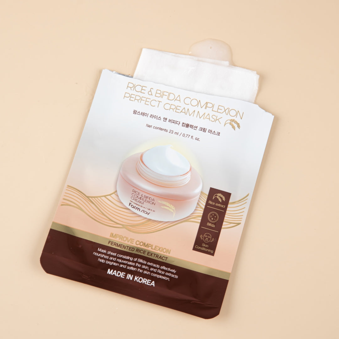Farmstay Rice & Bifida Cream Sheet Mask box with 10pcs, showing individual masks in packaging for nourishing skin.