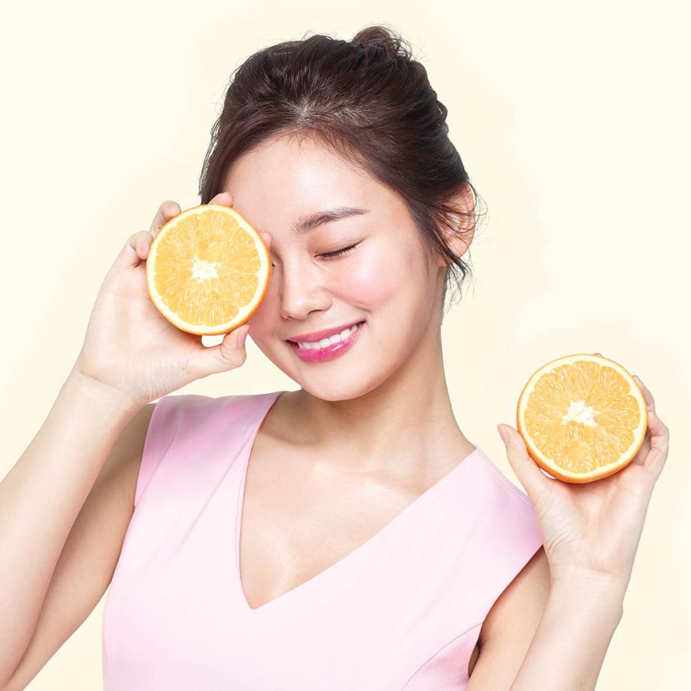 Frudia Citrus Brightening Cream face moisturizer in a jar with citrus fruit illustrations, highlighting natural ingredients and brightening effects.