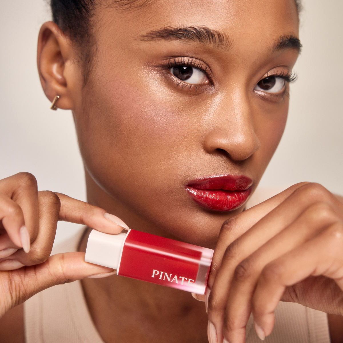 Pinate Natural Bloom Lip Oil Serum in clear lip gloss tube, showcasing glossy, hydrating lip gloss with natural ingredients.