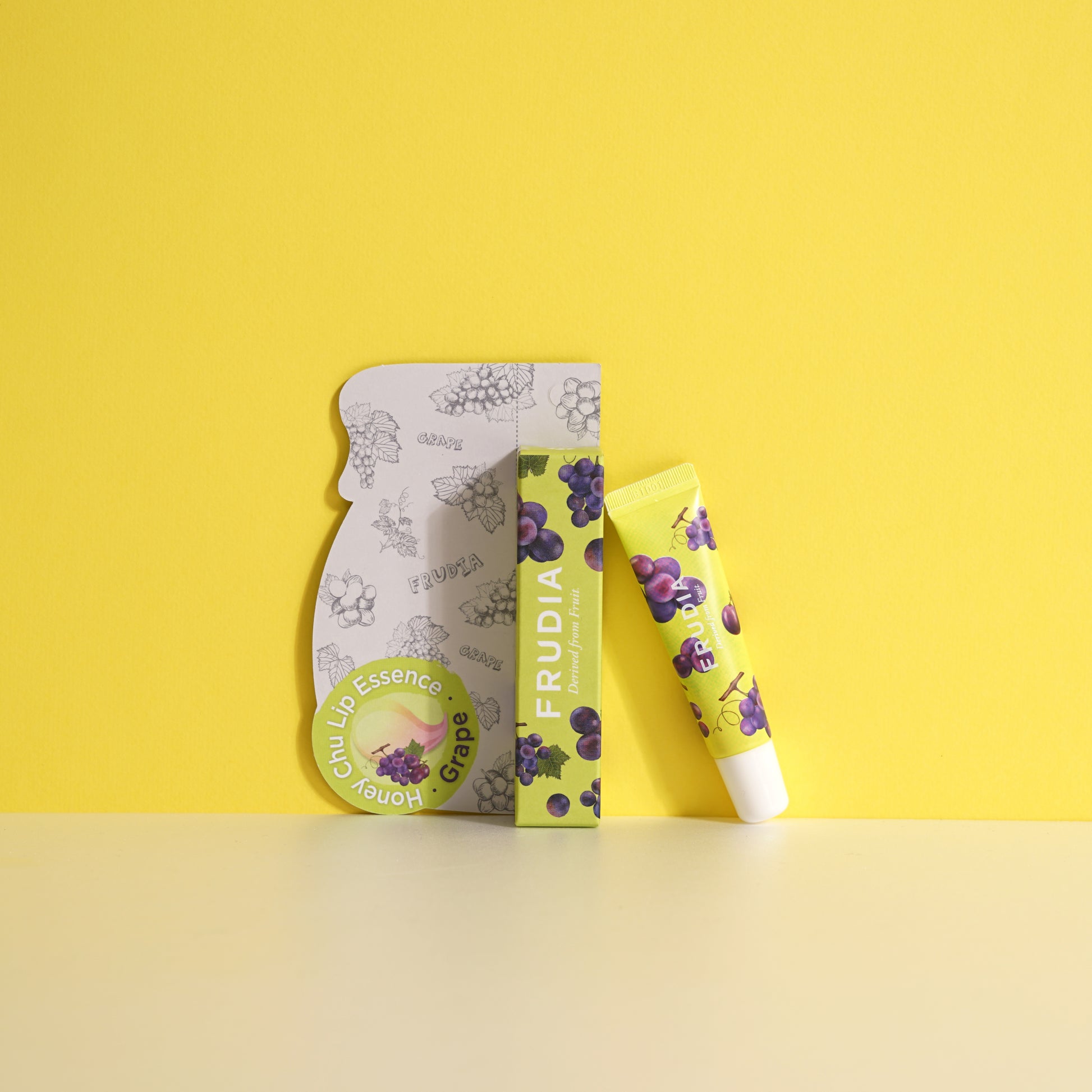 Frudia Grape Honey Chu Lip Essence 10g tube showing its smooth, hydrating lip balm and essence formula in a sleek container.