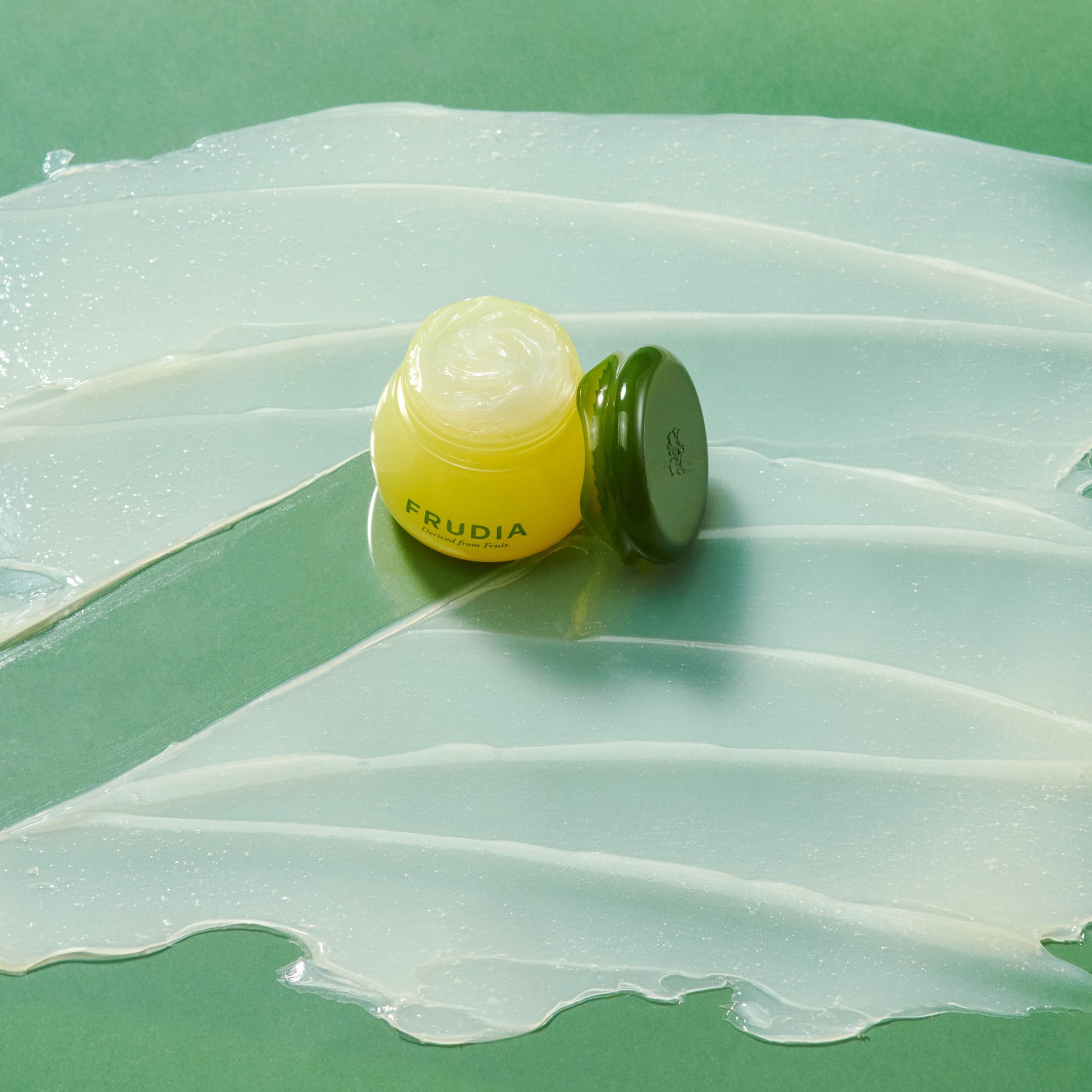 Frudia Avocado Cica Relief Lip Balm 10ml showing the tube with green and white packaging on a white background.
