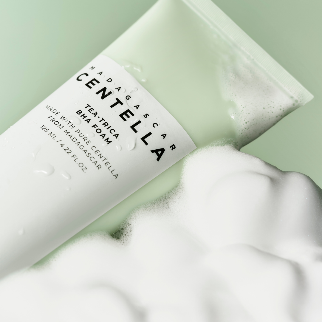 SKIN1004 Madagascar Centella Tea-trica BHA foam cleanser in 125ml bottle, showing gel and foam texture with leafy plant ingredients.