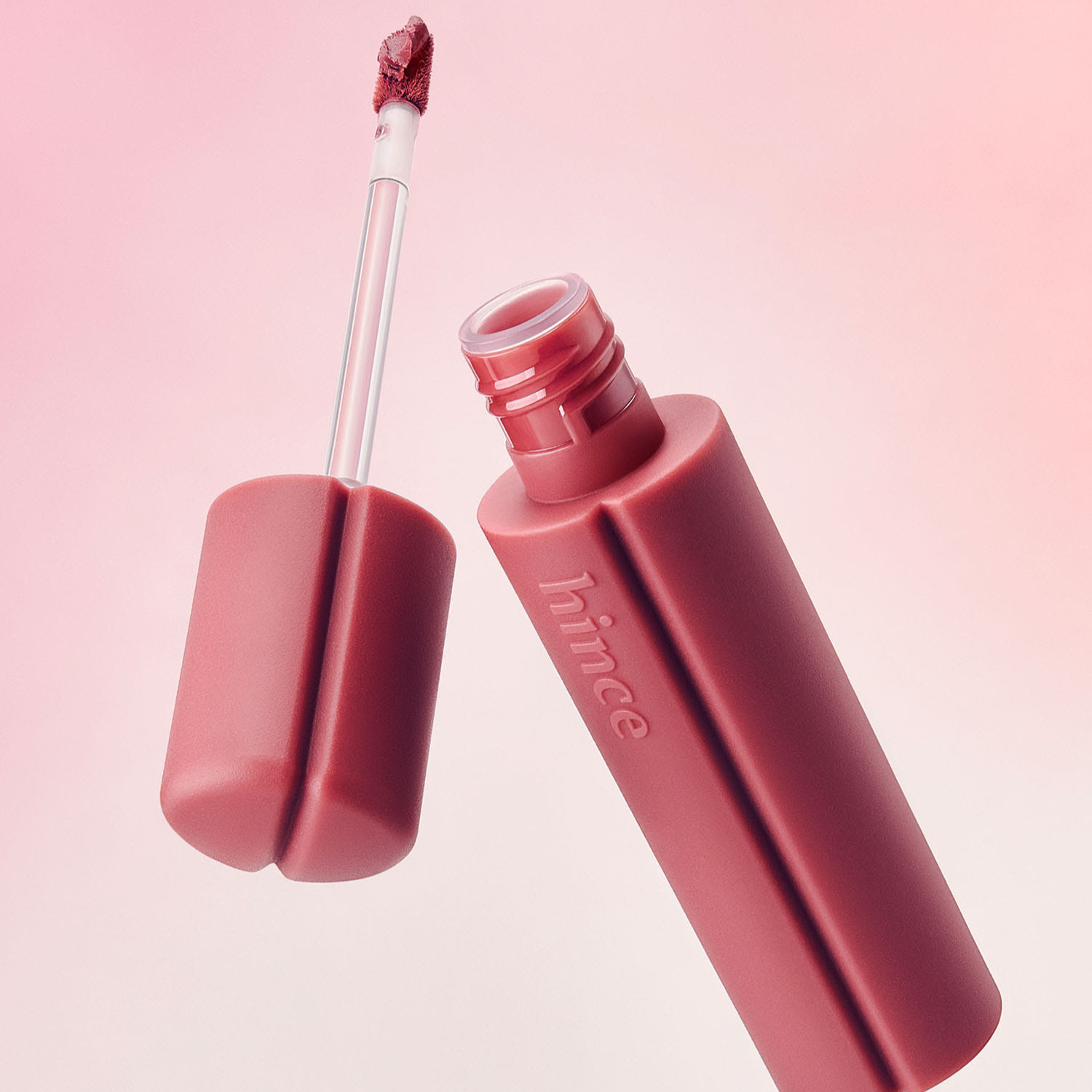 Hince Nu Blur Tint lip tint in a sleek tube, featuring a close-up of the applicator with soft, natural lip color visible.