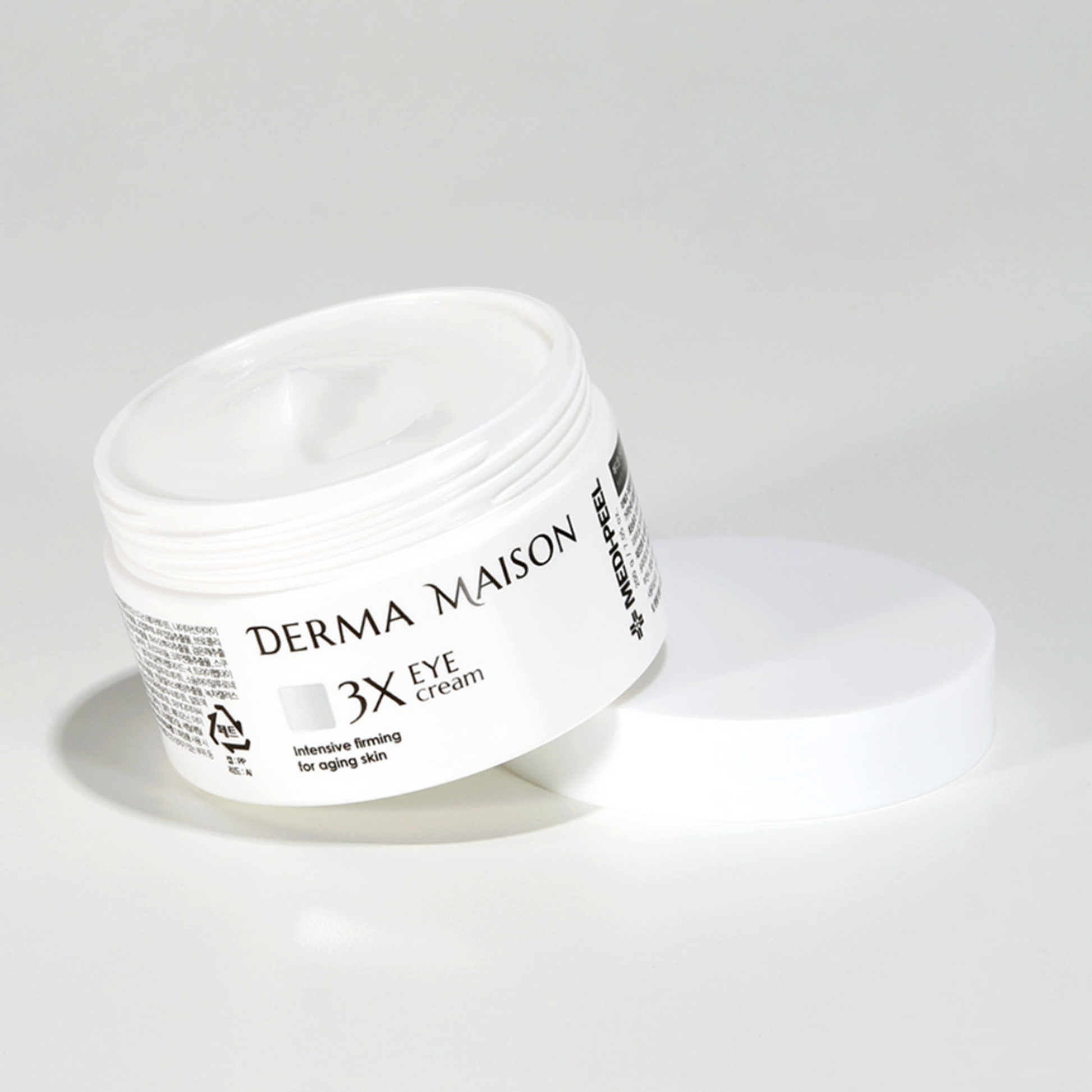 Derma Maison 3X Eye Cream in a sleek jar, showcasing its smooth texture and compact packaging for brightening and hydrating the eye area.