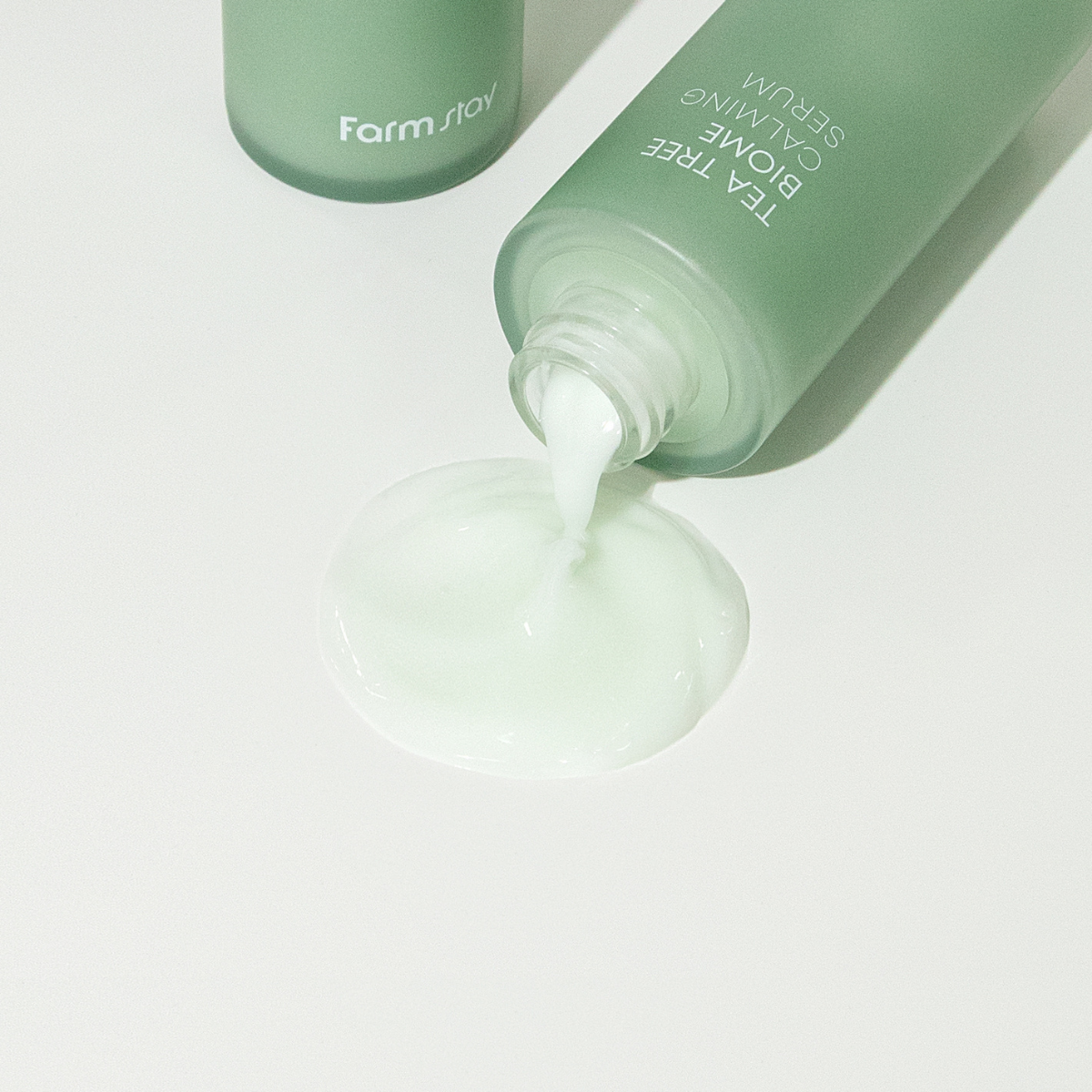 Farmstay Tea Tree Biome Calming Serum 50ml in a clear dropper bottle, featuring a green label and serum inside.