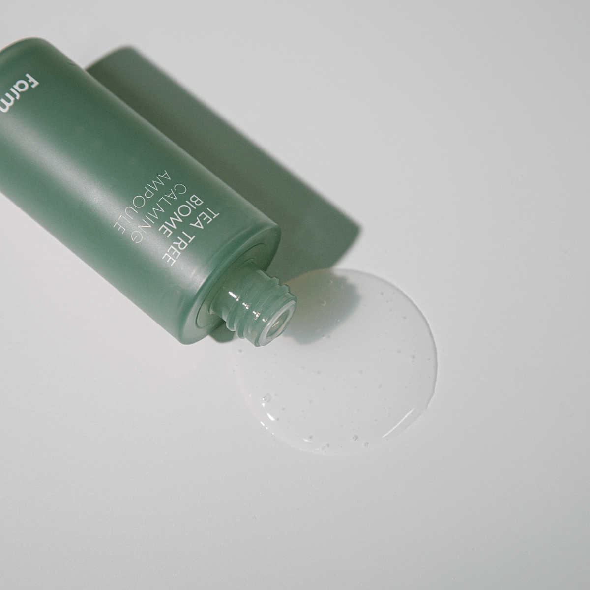 Farmstay Tea Tree Biome Calming Ampoule 50ml bottle with pump, featuring a clear glass container and white label with green accents.