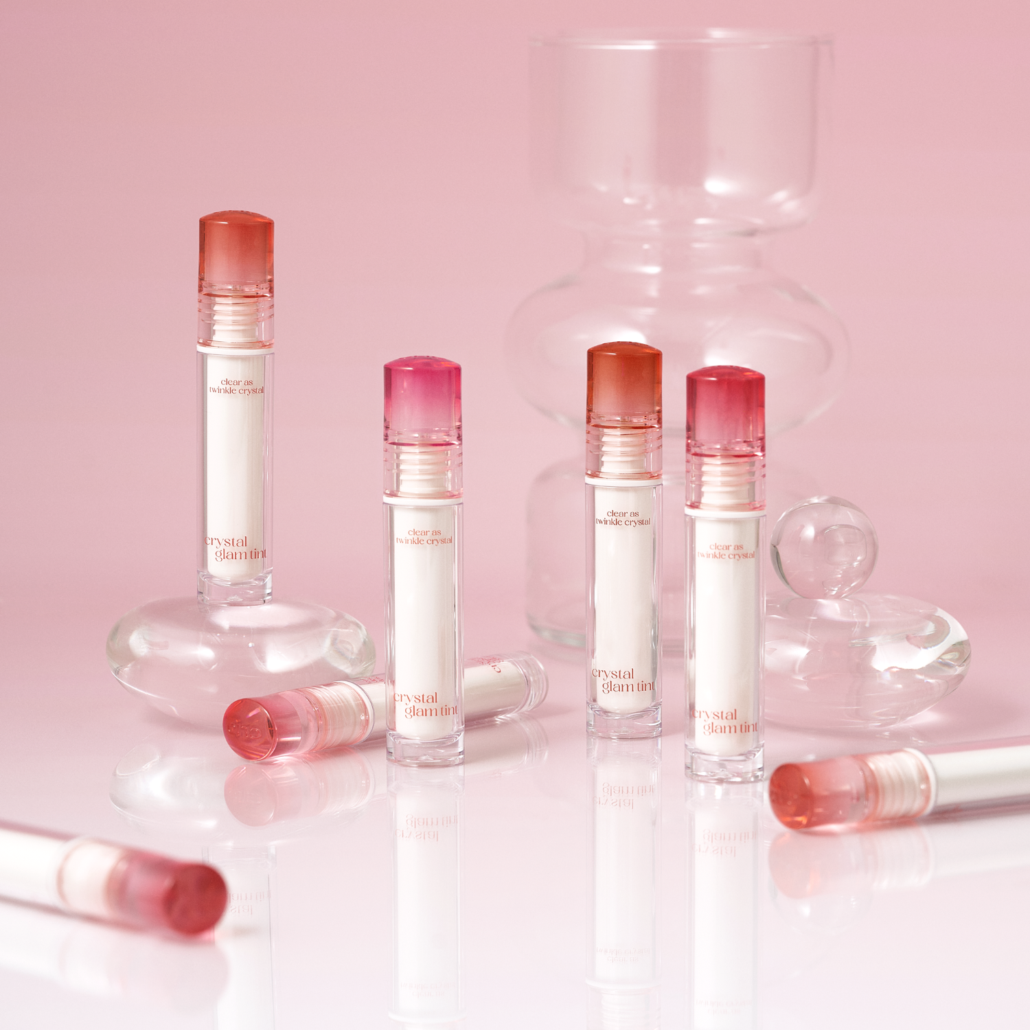 Clio Crystal Glam Tint lip tint in a clear glass bottle with a black cap, showcasing the product's glossy, shimmering finish.