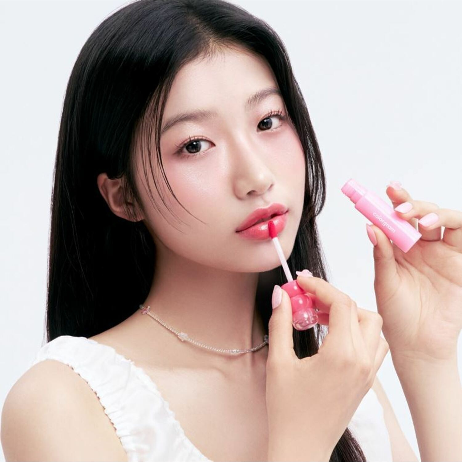 Colorgram Fruity Water Tint lip tint in a clear bottle with a vibrant pink liquid, showcasing the product's colorful design.