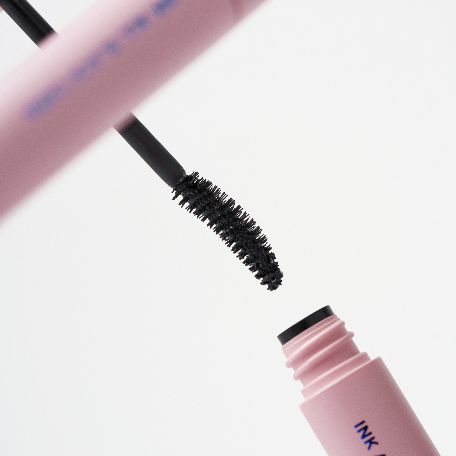 Peripera Ink All Black Cara mascara wand showing long, volumizing black mascara on lashes.