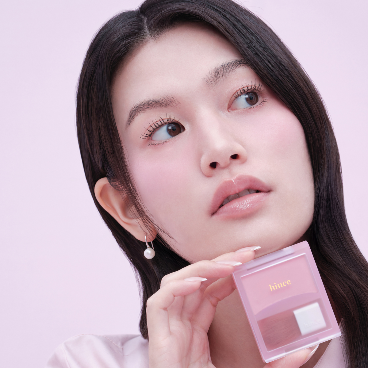 Hince Hug Layer Cheek Blush in a compact container with a soft pink shade, featuring a smooth, blendable powder blush surface.