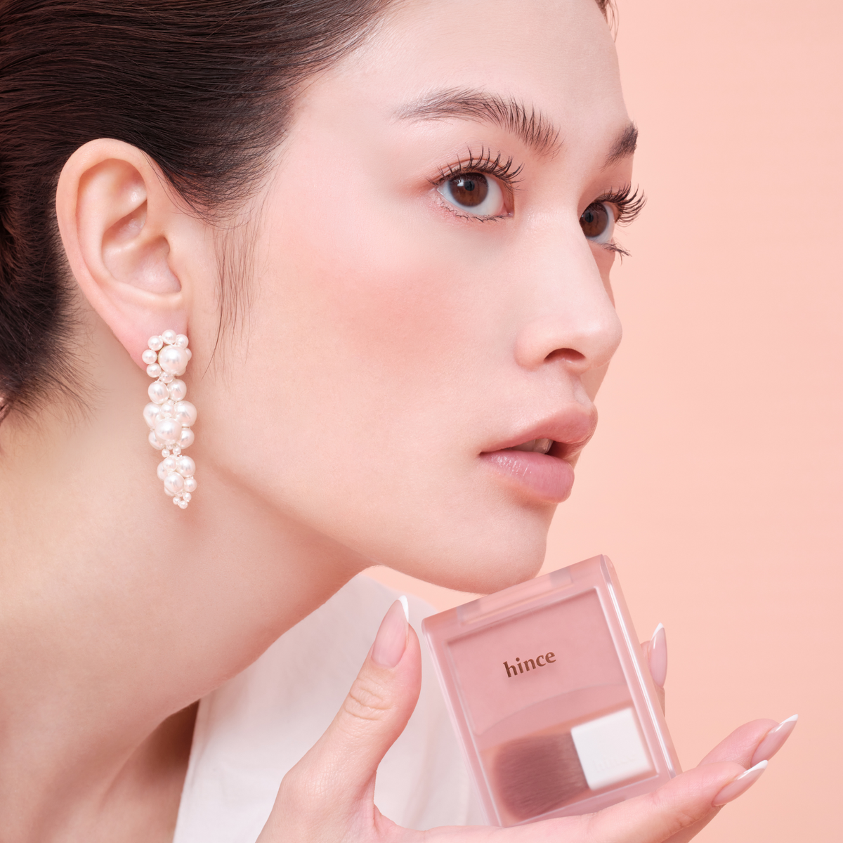 Hince Hug Layer Cheek Blush in a compact with pink-toned powder, showcasing its smooth texture and subtle color.
