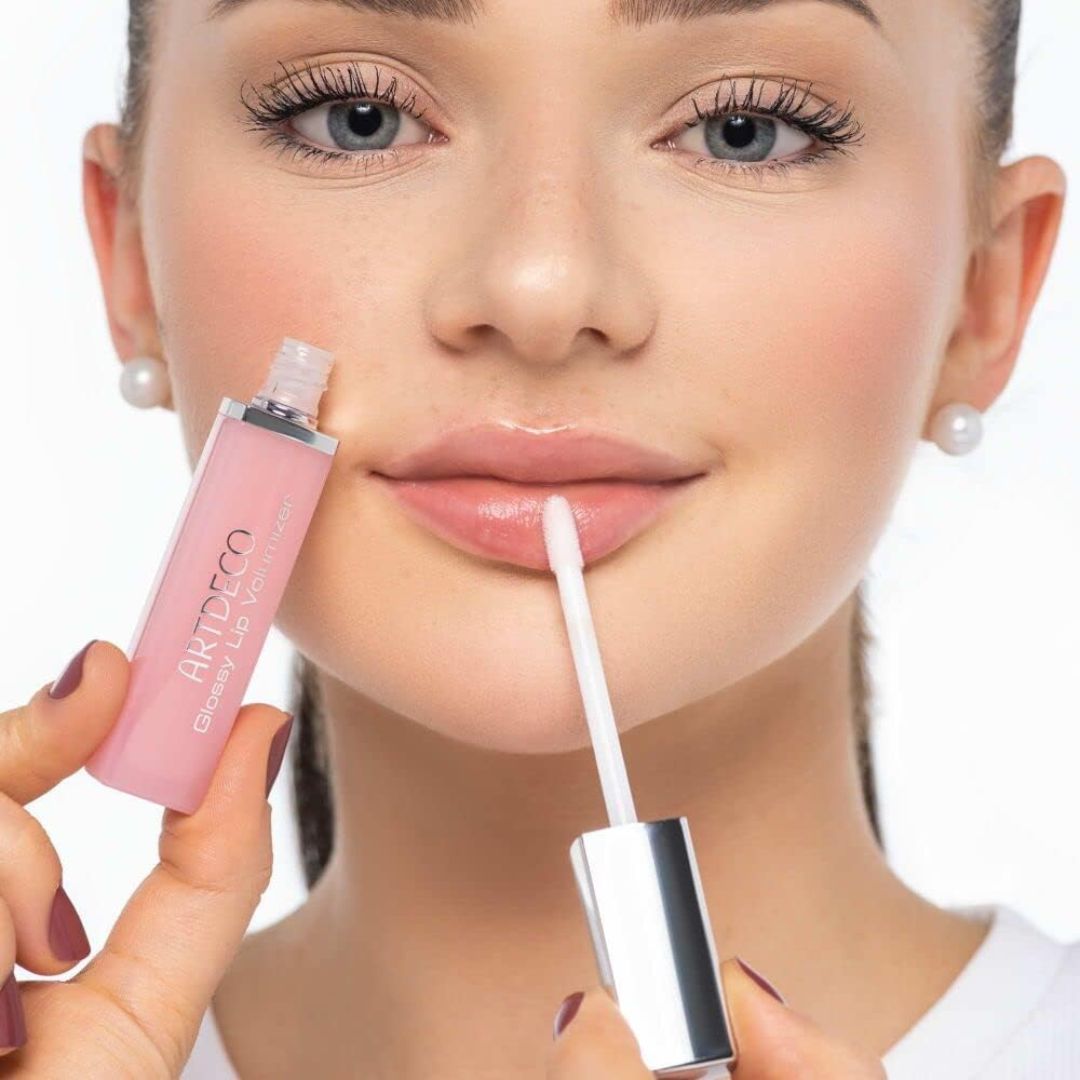 ARTDECO glossy lip volumizer lip plumper with shiny finish on lips, enhancing fullness and hydration.