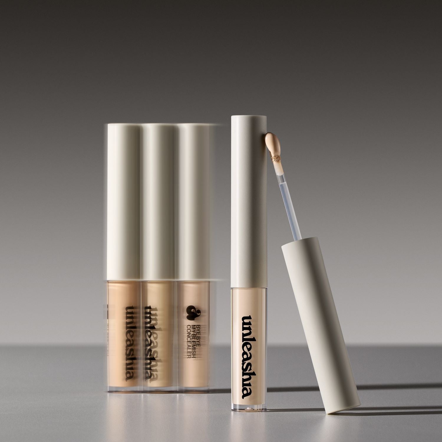 Unleashia Bye Bye My Blemish Concealer in two shades, showing the compact container and swatches on skin for coverage.