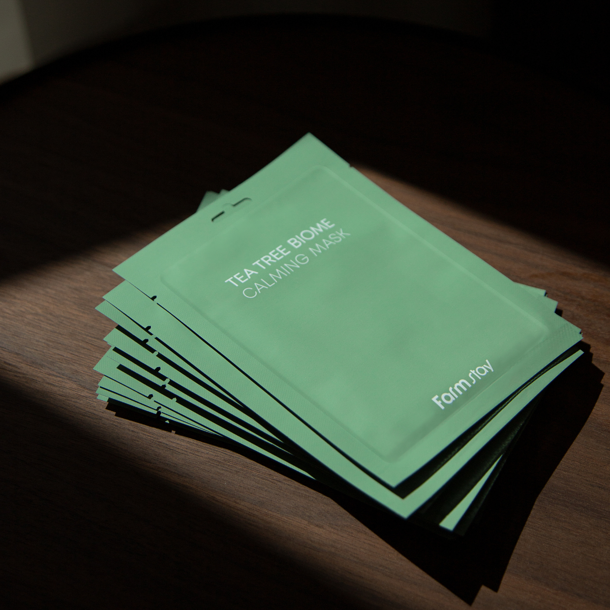 Farmstay Tea Tree Biome Calming Sheet Mask 10pcs, soothing facial mask with tea tree extract, laid out on a white background.