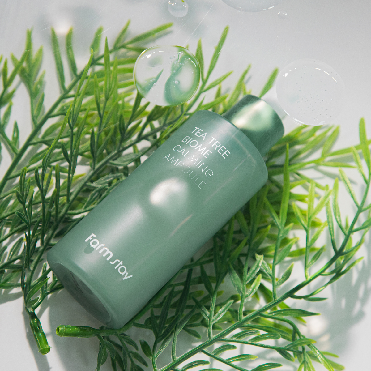 Farmstay Tea Tree Biome Calming Ampoule 50ml bottle with clear liquid and green label, designed for soothing skin.
