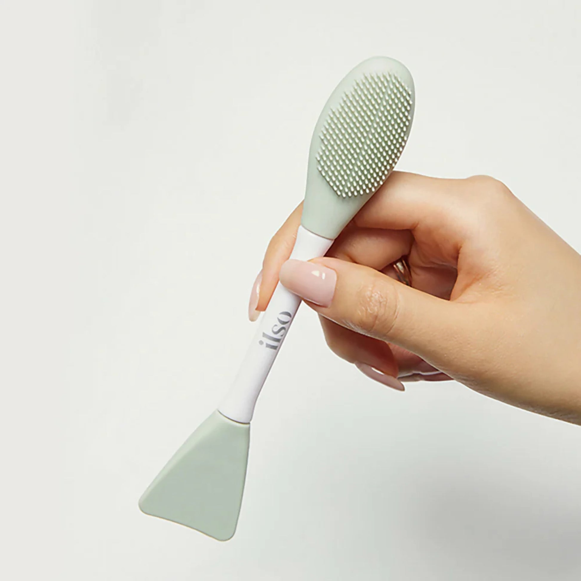 ILSO Dual Clean Brush beauty tool with dual-sided bristles for gentle skin cleansing and exfoliation.