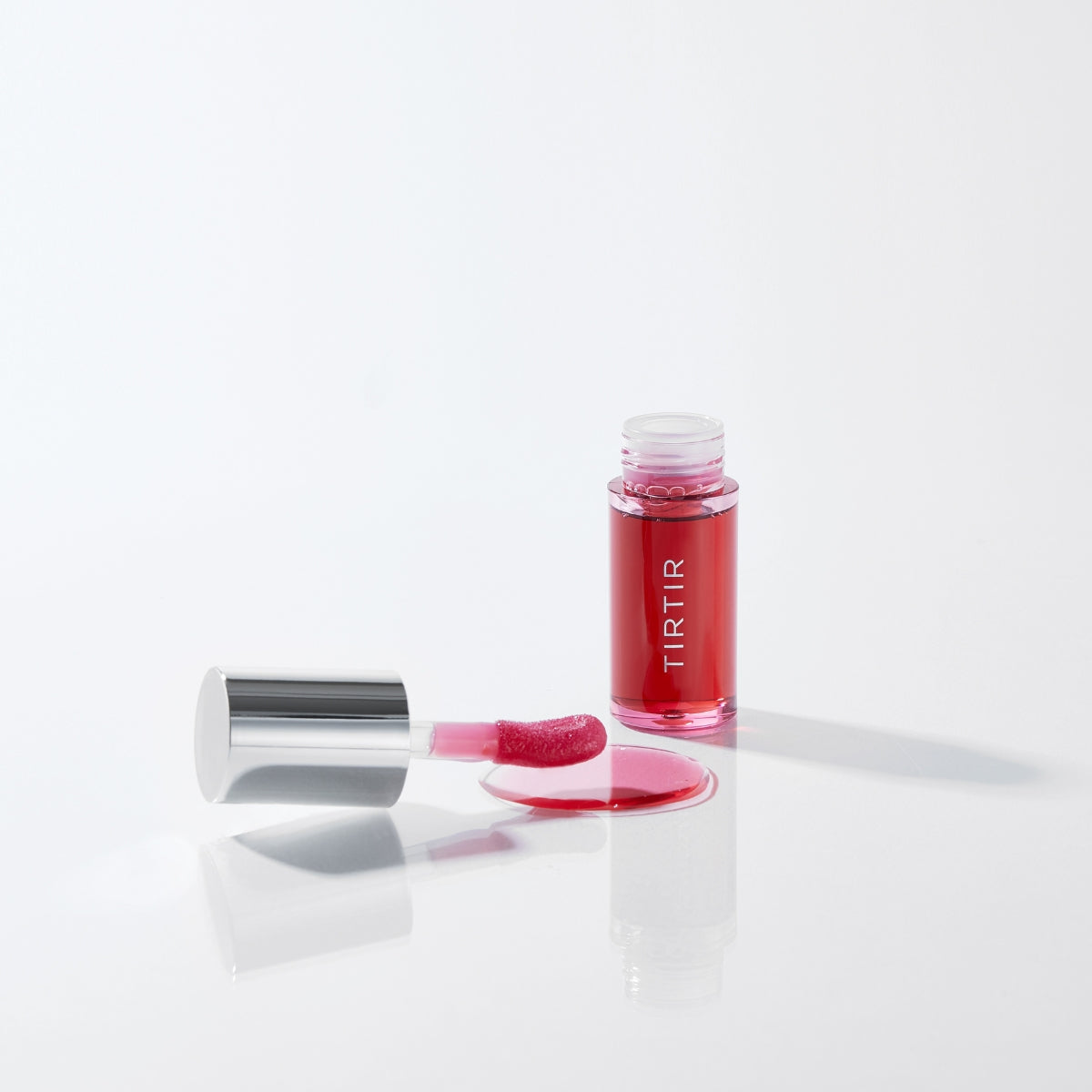 TIRTIR My Glow Lip Oil Rosy 5.7ml in a clear tube with a glossy applicator, showcasing a pink tinted lip gloss.