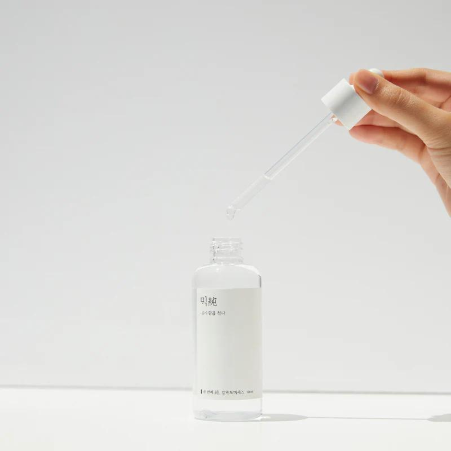 Mixsoon Galactomyces Ferment Essence 100ml in a clear bottle, showing the light-colored liquid and minimalist packaging.