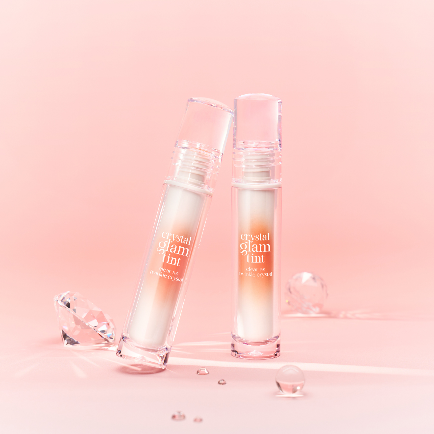 Clio Crystal Glam Tint luxury lip tint in a sleek tube, featuring a clear cap and a soft pink shade for a glossy lip look.