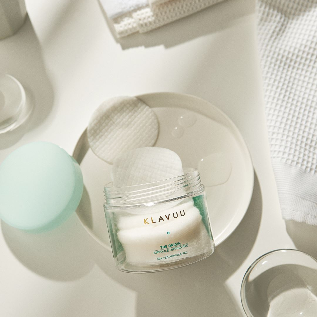 Klavuu The Origin Ampoule Dipping Pad 50pcs, toner pads for skincare, shown stacked with pink and white packaging.