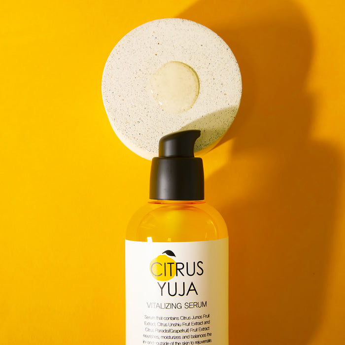 Farmstay Citrus Yuja Vitalizing Serum in a 100ml bottle, featuring bright yellow citrus fruit and serum dropper.