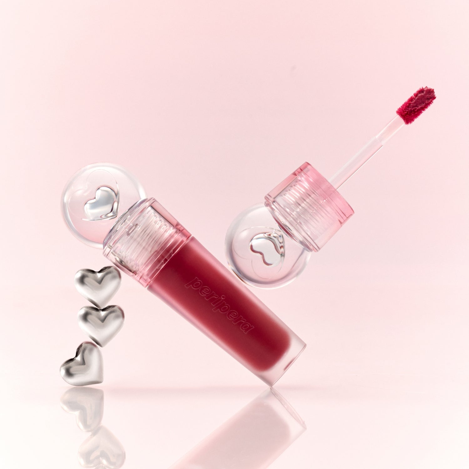 Peripera Ink Jellable Lip Tint in a vibrant pink shade, showing the glossy, jelly-like texture and applicator wand.