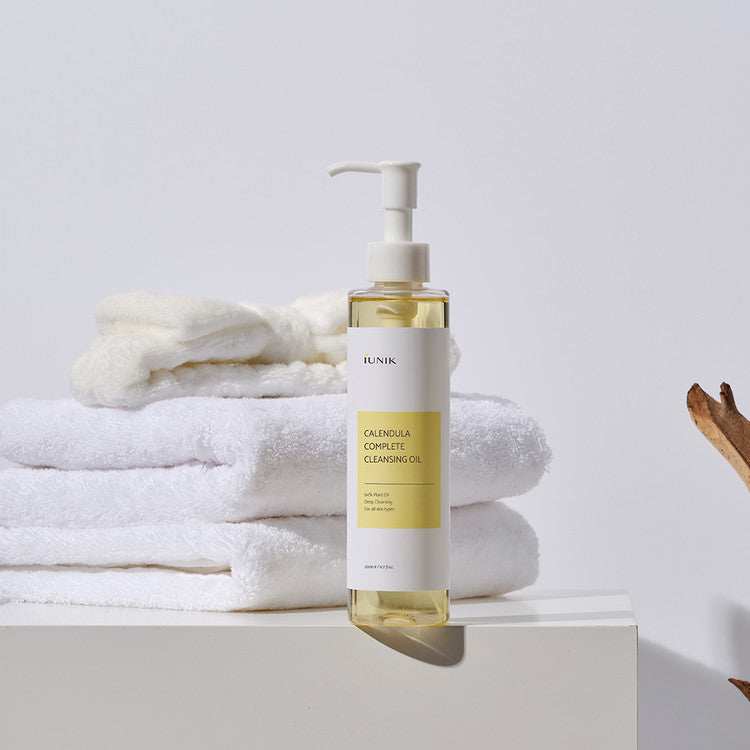 iUNIK Calendula Complete Cleansing Oil in a 200ml bottle, featuring clear liquid and pump dispenser for gentle facial cleansing.