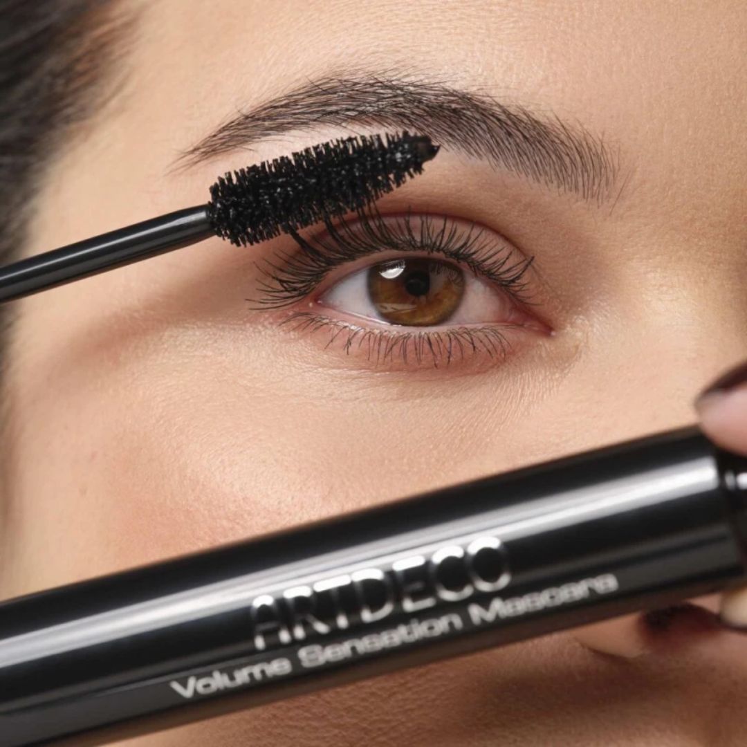 Black ARTDECO Volume Sensation Mascara with thick, voluminous lashes in a sleek mascara tube.