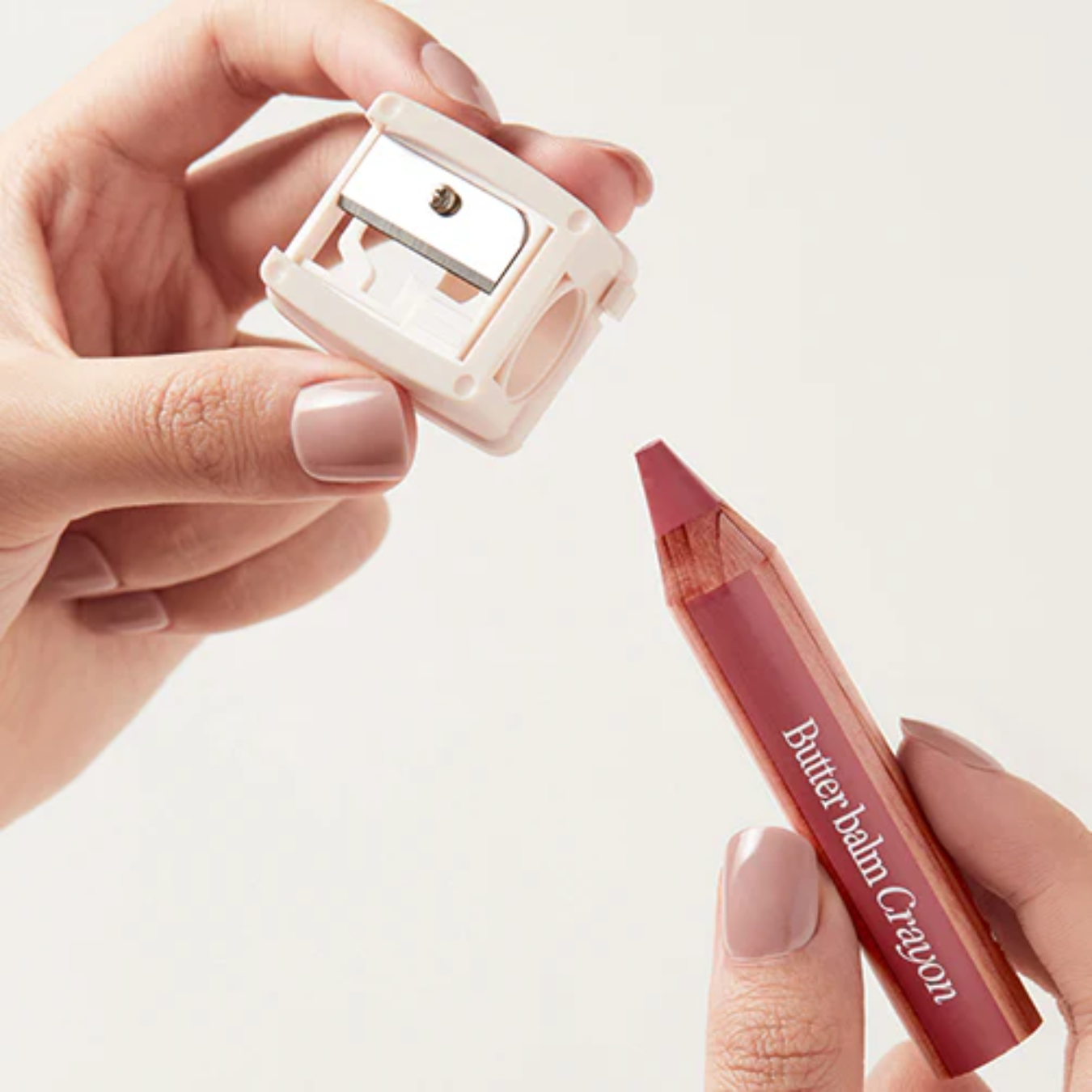 Clio Butter Balm Crayon lipstick with matching sharpener, featuring creamy, moisturizing lip color in a sleek crayon format.