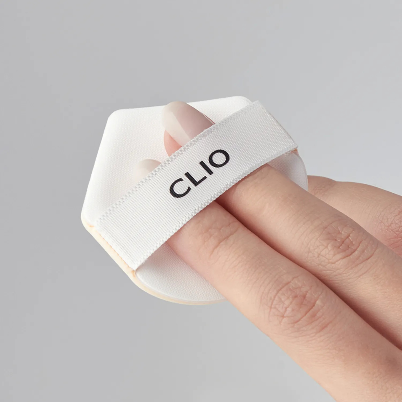 Clio Kill Cover Founwear Cushion The Original Puff with sponge applicator, shown in a model image, for flawless makeup application.