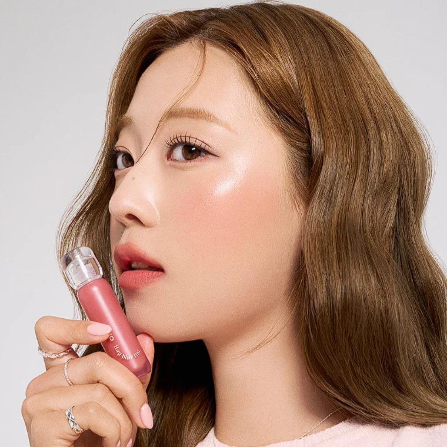 Clio Hug Blur Lip Tint in a soft, natural shade, showcasing the creamy texture and sleek packaging of the lip tint product.