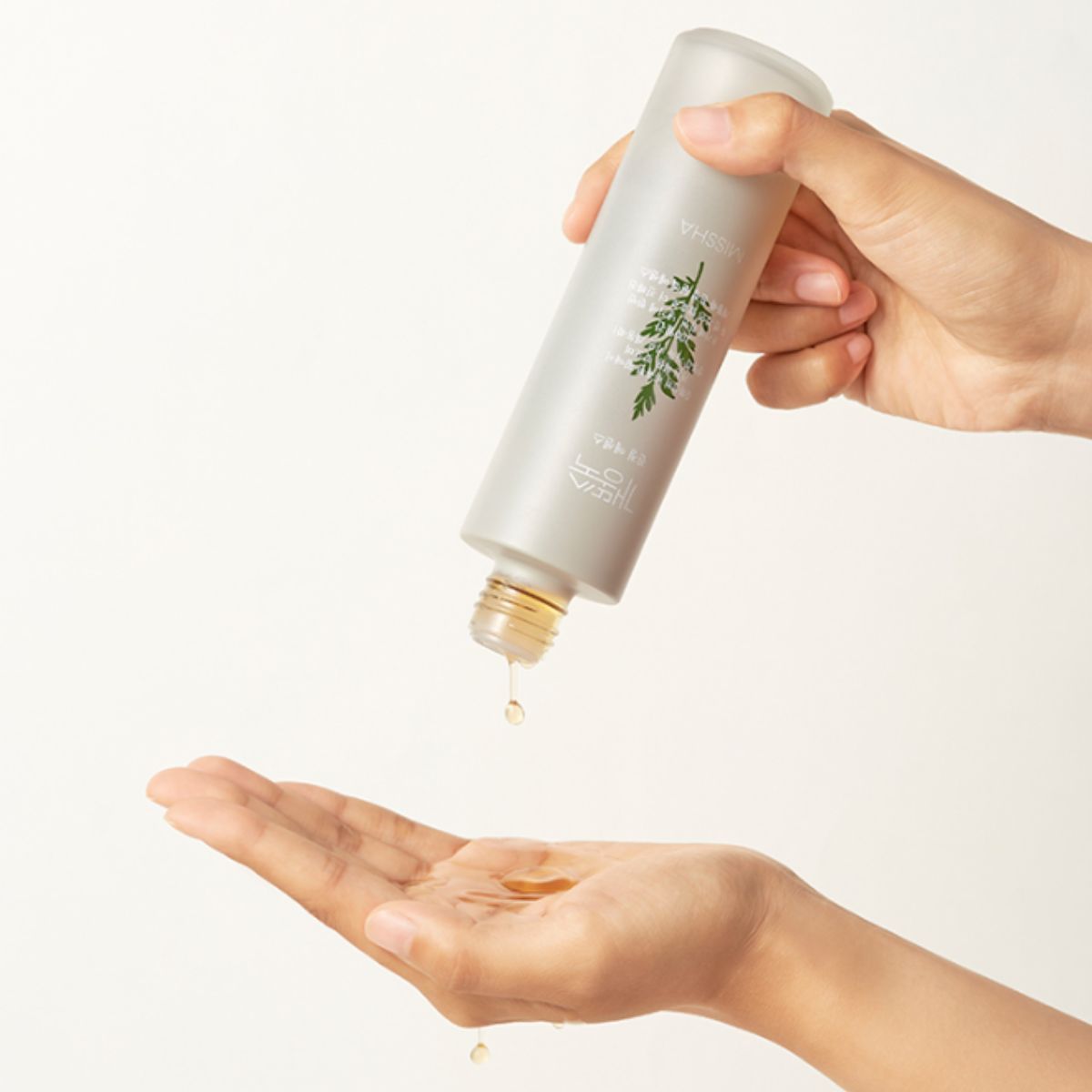 Missha Artemisia Calming Essence in a 150ml bottle, showing the glass container and label with herbal branding.