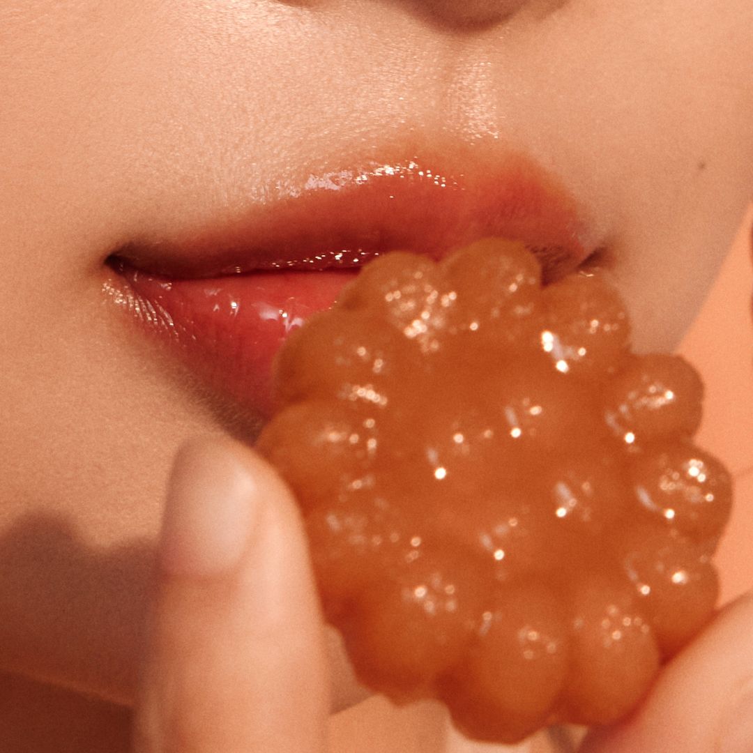 Peripera Ink Mood Glowy Tint in Honey K-ookie version, close-up of the lip tint applicator with the product packaging visible.