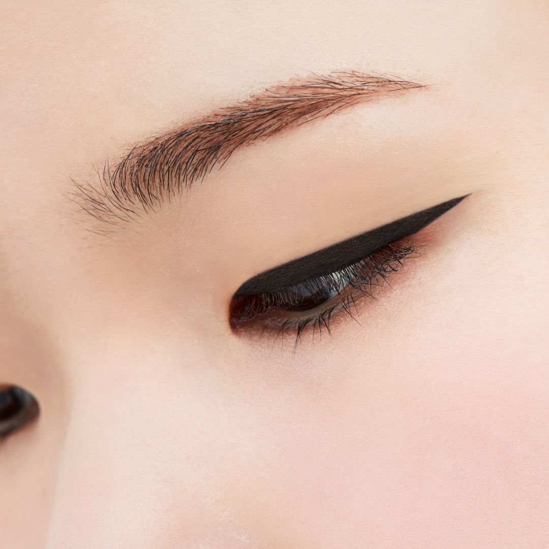 Close-up of a woman's eye with Sharp So Simple Waterproof Liquid Eyeliner by Clio applied along the upper lash line.