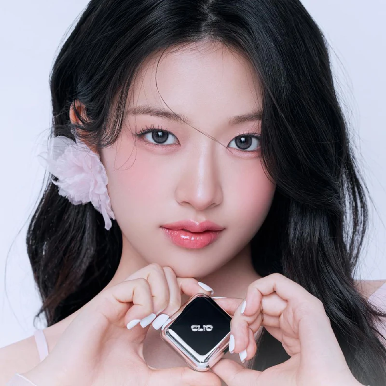 Clio Essential Lipcheek Tap blush in a soft pink shade, featuring a compact design with the blush product visible inside.