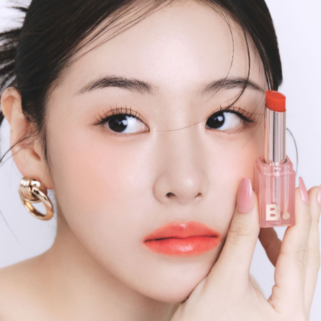 Banila Co B. By Banila Glow Veil Lipstick in OR01 shade, showing the sleek lipstick tube with a soft pink hue.