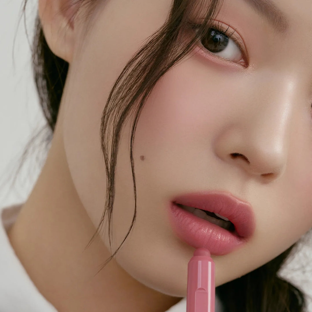 Peripera Slip On My Lip lipstick in soft pink shade, displayed in a sleek tube with the cap removed revealing the lipstick tip.