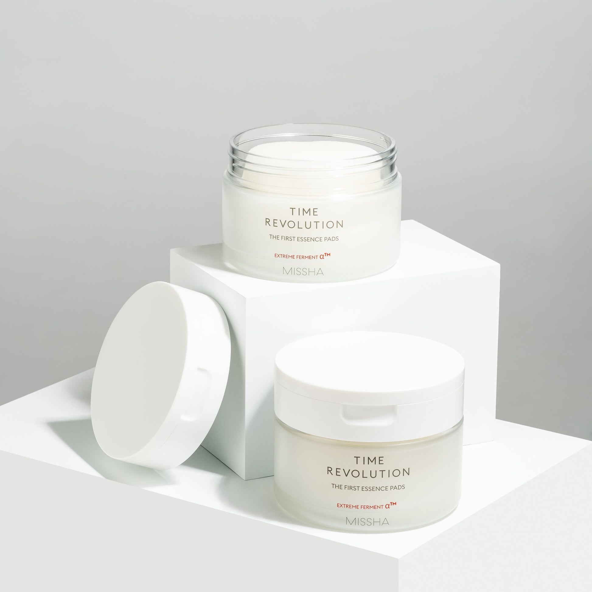 Missha Time Revolution The First Essence Toner Pad 75pcs, close-up of the box with individual pads arranged neatly.