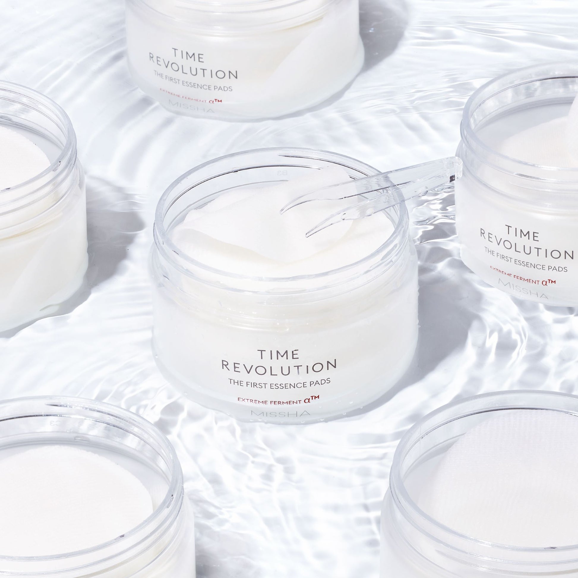 Missha Time Revolution The First Essence Toner Pad, 75pcs, showing a close-up of the skincare product in a sleek pad container.