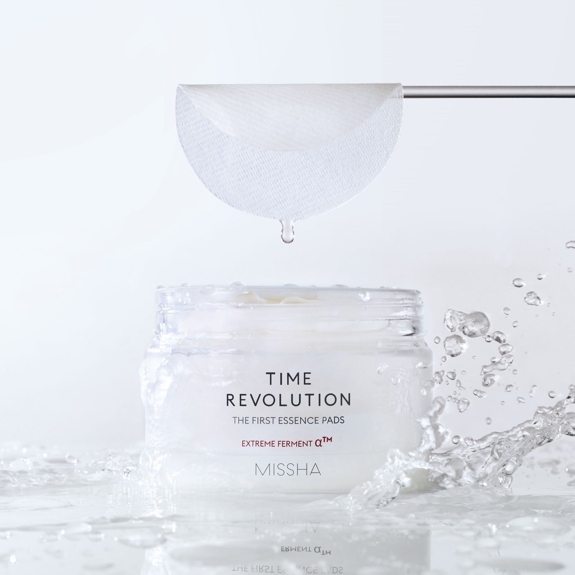 Missha Time Revolution The First Essence Toner Pads, 75-pack, showing a close-up of the skincare product in a jar and individual pads.