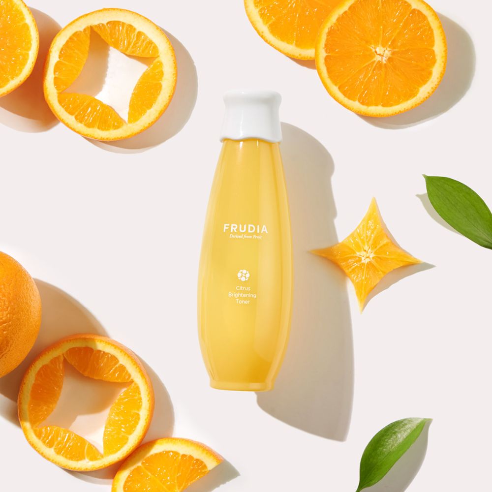 Frudia Citrus Brightening Toner 195ml bottle with clear liquid and orange citrus fruit, suitable for skin brightening and hydration.
