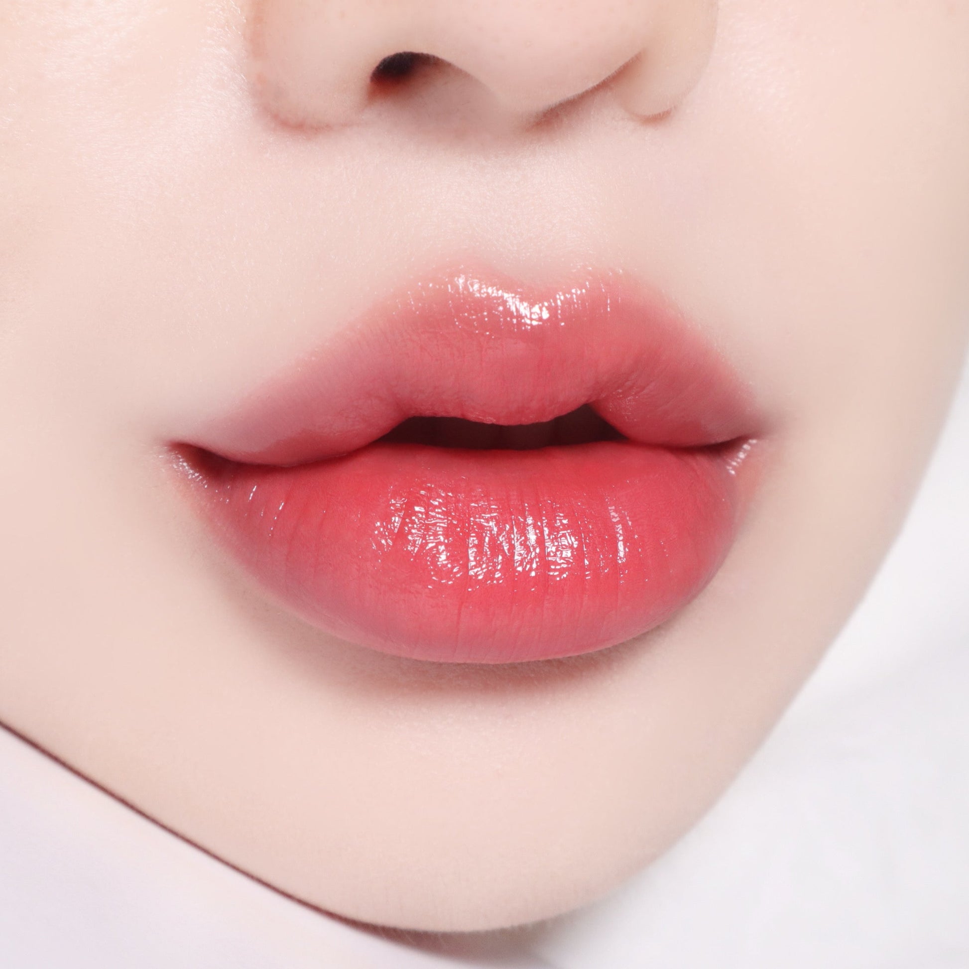 Banila Co B. By Banila Glow Veil Lipstick in soft pink shade, showcasing smooth, full lips with a glossy finish.