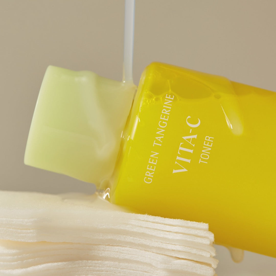 Goodal Green Tangerine Vita C Toner in a 300ml bottle with a cotton pad, featuring vibrant green tangerine imagery.