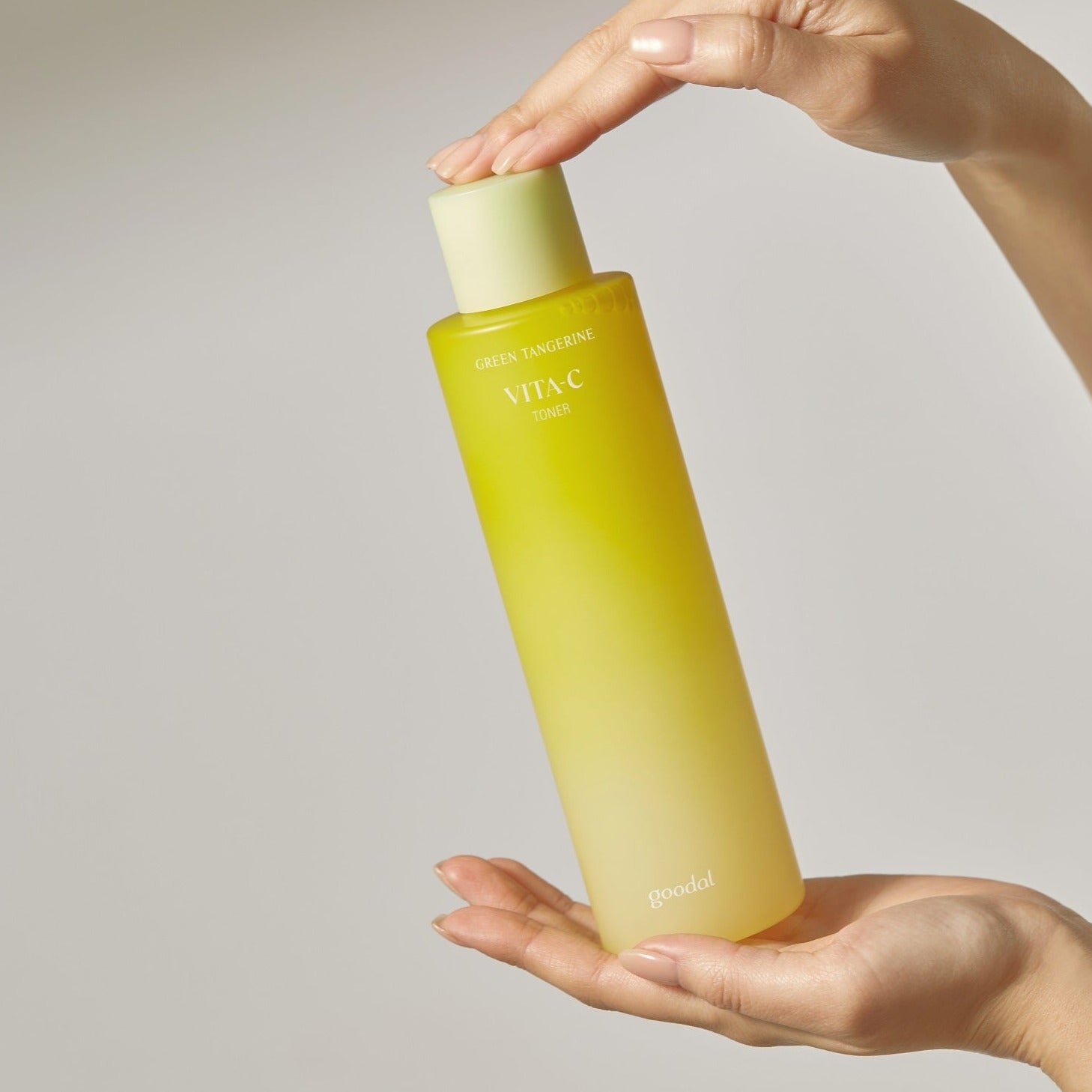 Goodal Green Tangerine Vita C Toner in a 300ml bottle with a hand holding it, showcasing the bright packaging and product label.